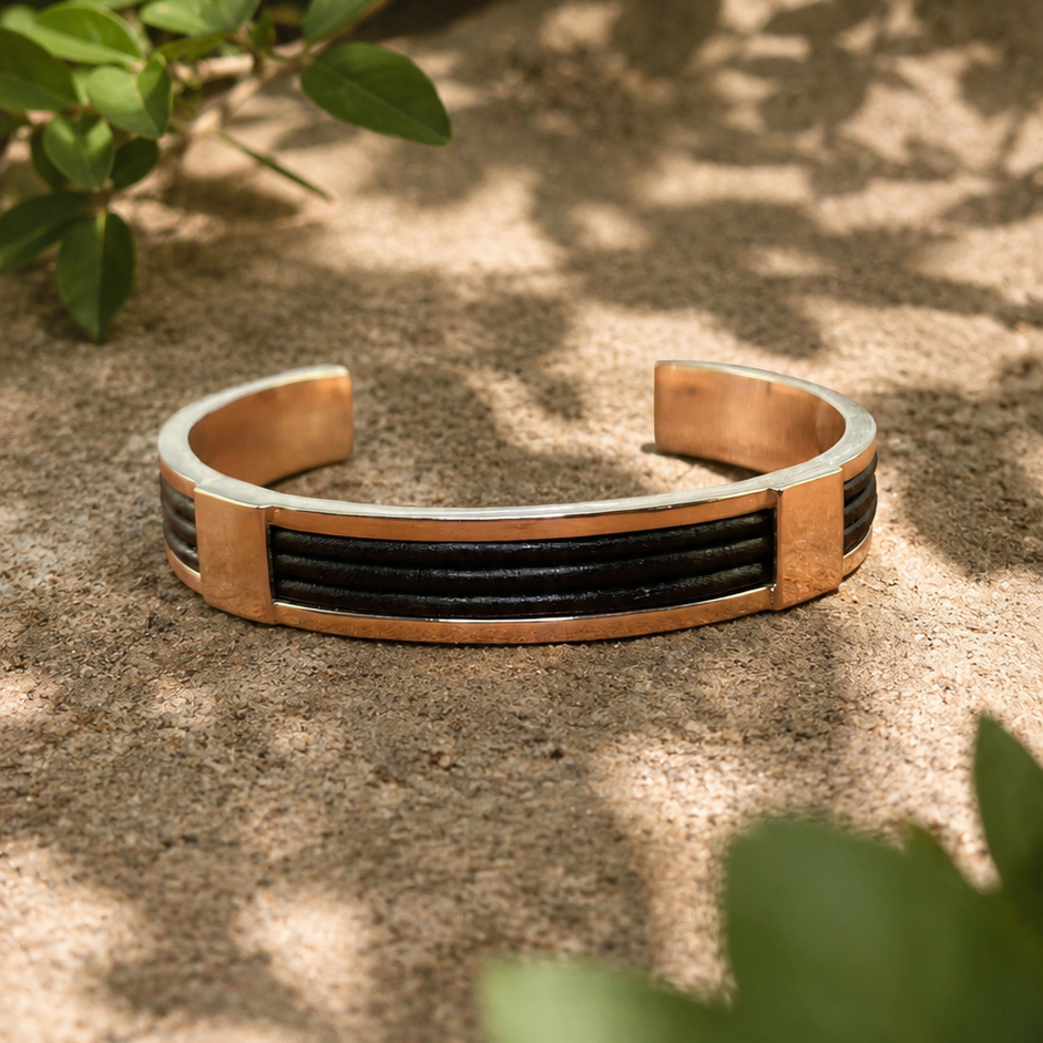 Handcrafted sterling silver leather cuff bracelet displayed outdoors in natural dappled light.
