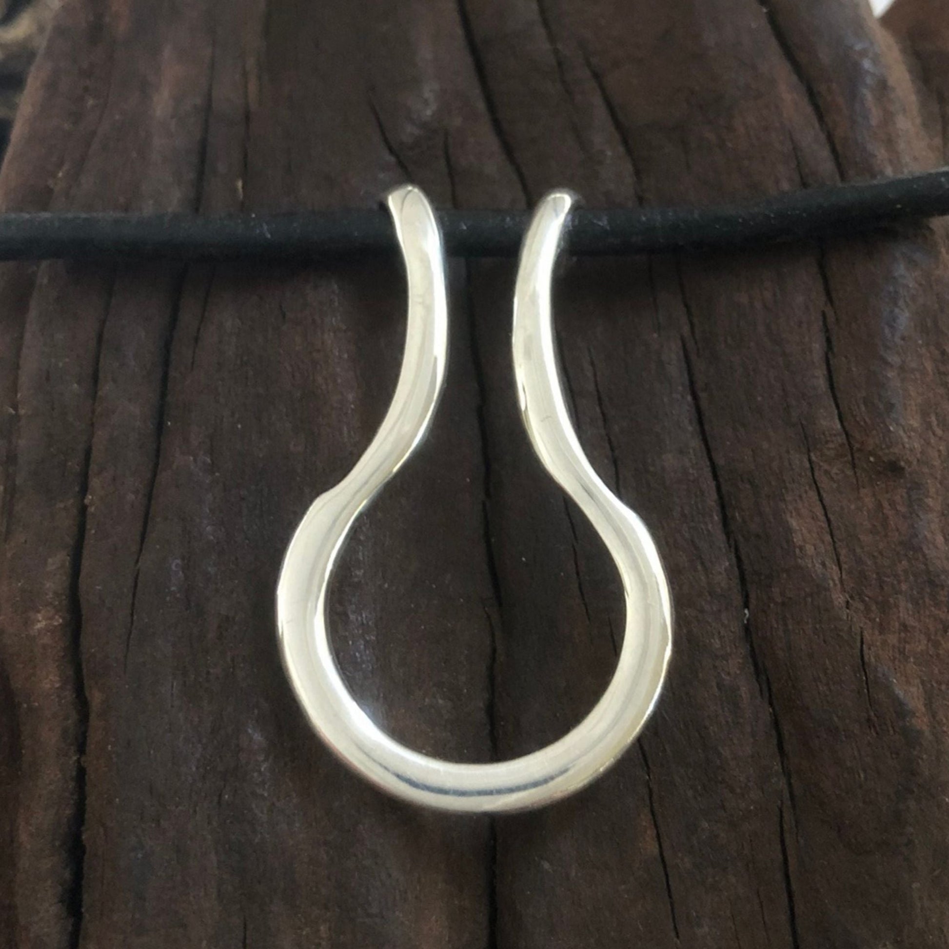 Silver ring saver pendant on a leather necklace. 