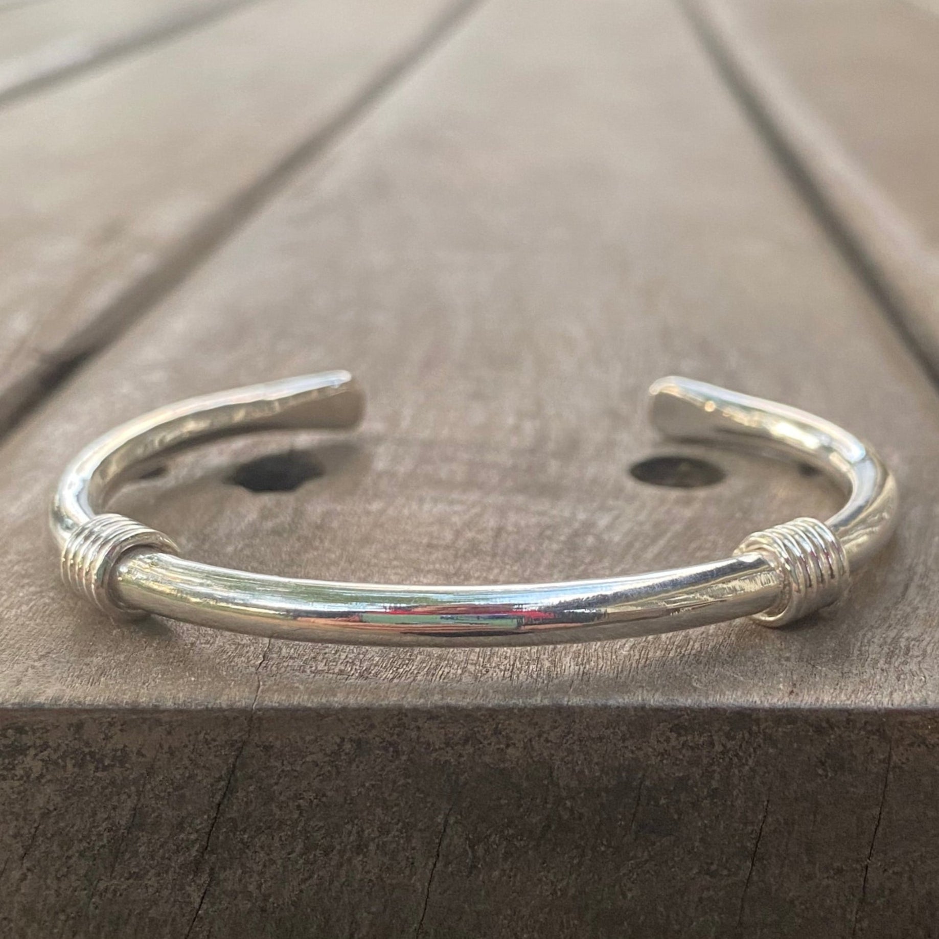 Silver bangle photographed on a table top