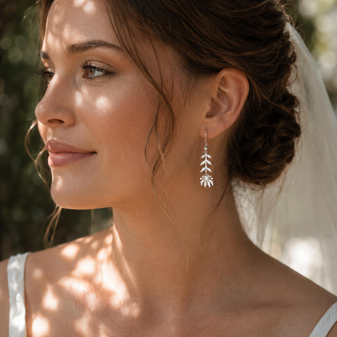 Woman wearing handcrafted sterling silver Flame Lily earrings inspired by Zimbabwe's national flower.