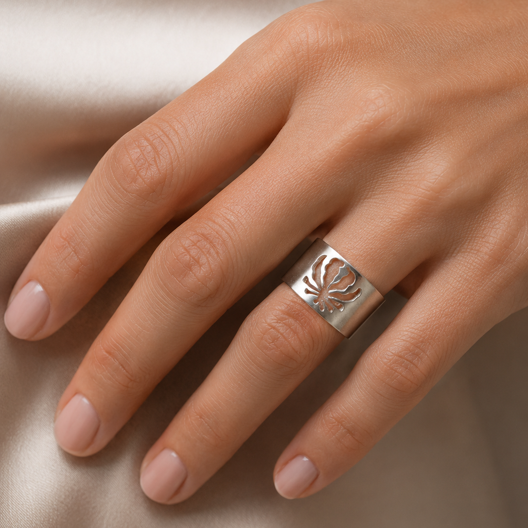 Woman wearing a handcrafted sterling silver Flame Lily band inspired by Zimbabwe's national flower.