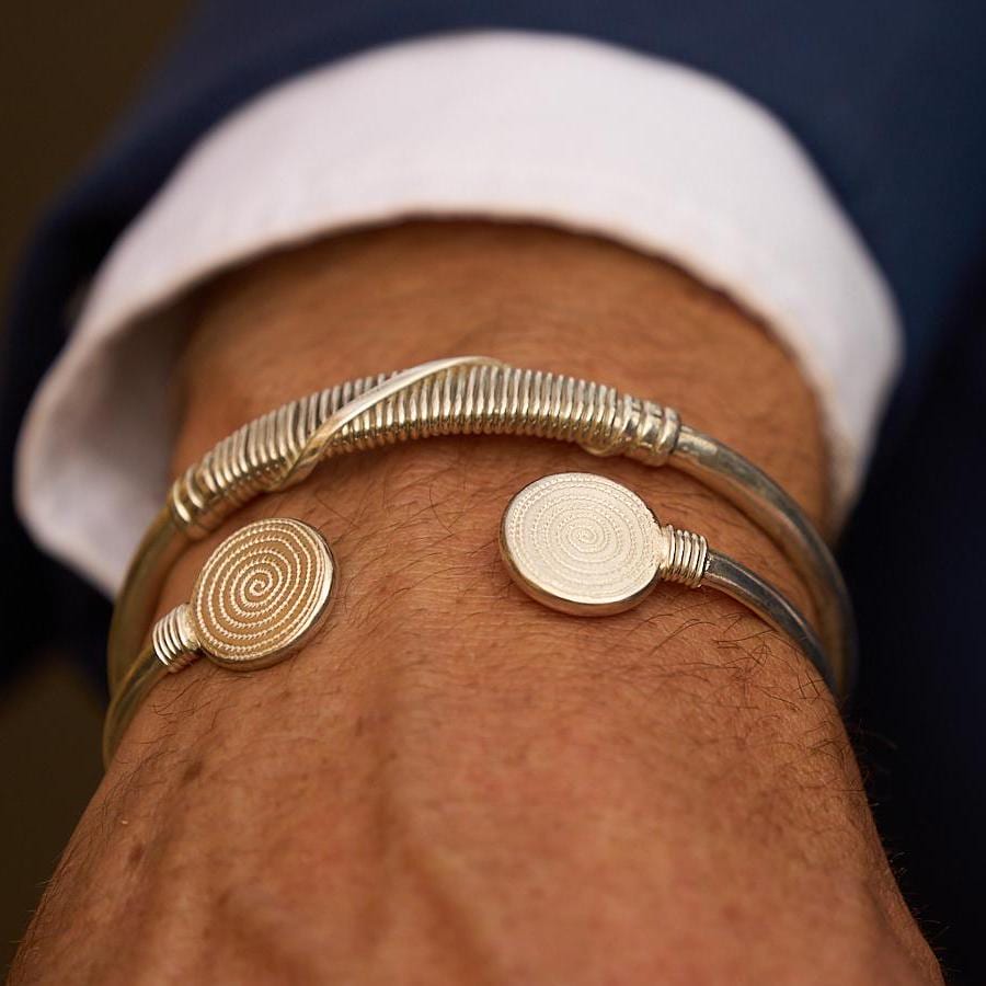 Man wearing a handcrafted sterling silver Double Ndoro cuff bangle inspired by Great Zimbabwe.