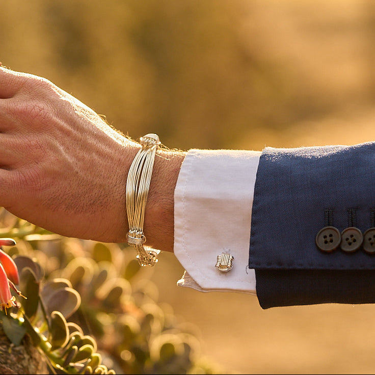 Sterling Silver Elephant Knot cufflinks worn with a navy suit and white shirt cuff, handcrafted in Zimbabwe.